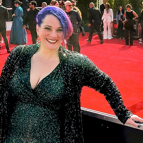 Alexandra Dietrich with bright purple and pink hair, wearing a sparkly dark dress, on the red carpet at the 2023 Grammy Awards. Photo courtesy of Alexandra Dietrich.