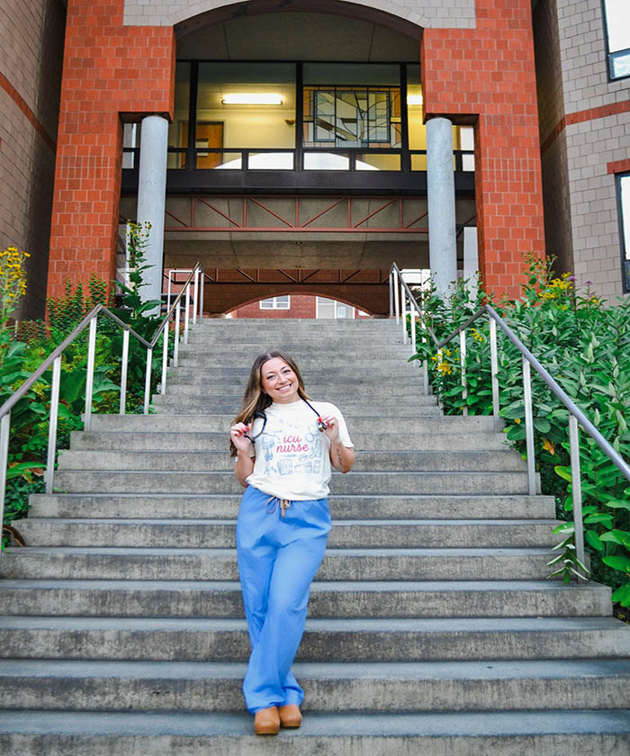 Recent USM accelerated nursing graduate Jaden Dalrymple standing on the Portland, Maine campus.