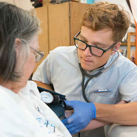 A nursing student practices taking a person blood pressure.