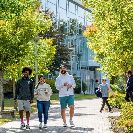 Three students walk down the sidewalk of our Portland campus on a sunny day.