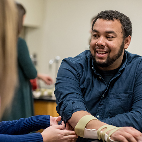 A student of Occupational Therapy practices with an arm splint.