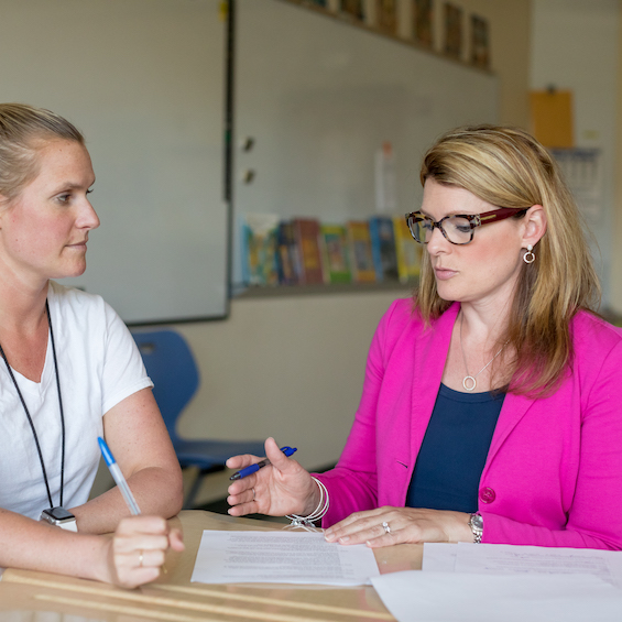 A teacher meets with a student to discuss an assignment.
