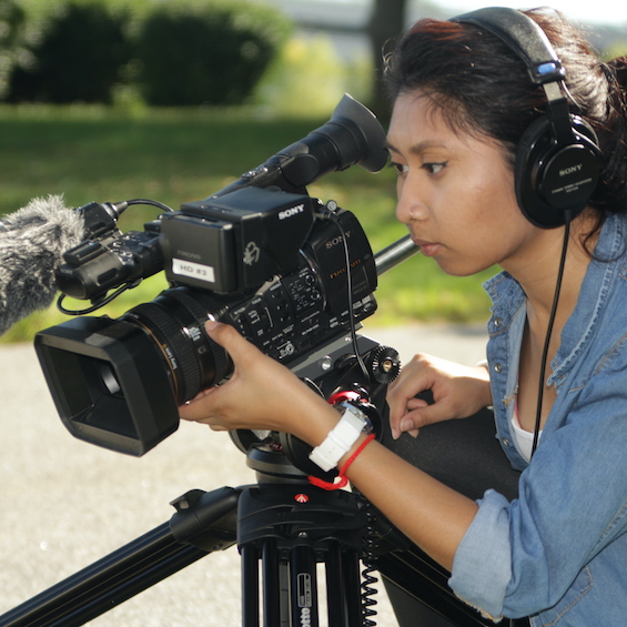 A student uses a camera to film a project.