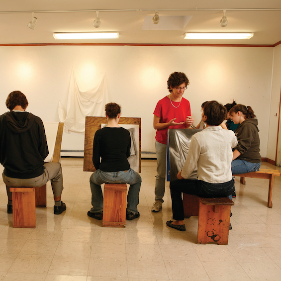 Several students work on their pieces during a still-life drawing session.