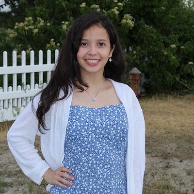 Ashley Salguero-Gonzalez ‘23 smiles for the camera while wearing a blue dress and white cardigan.