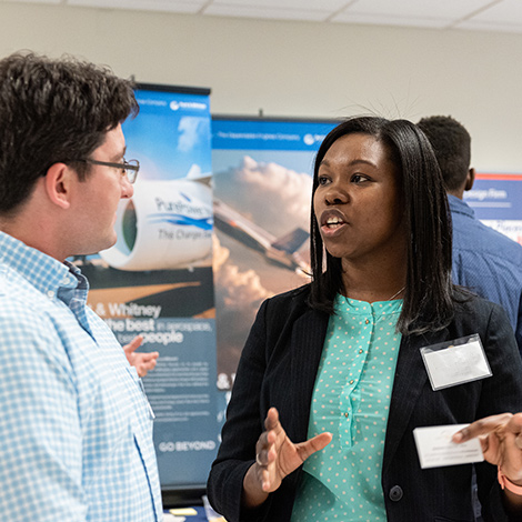 A Southern Maine employer speaks with a student at a job and internship fair.