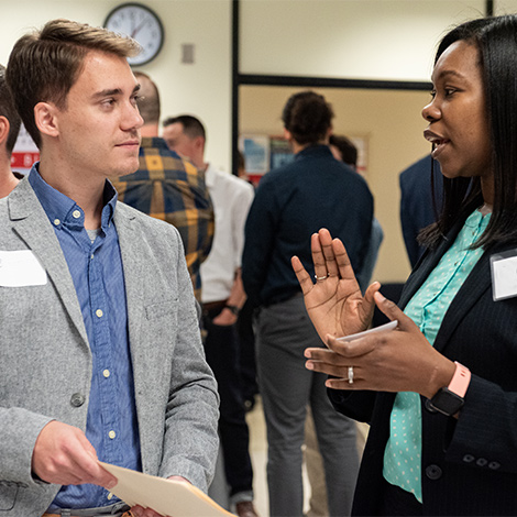 A Southern Maine employer speaks with an engineering student at a job and internship fair.