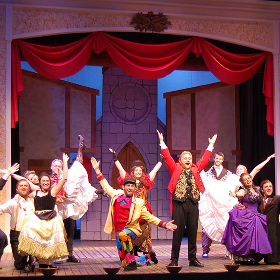 The cast of The Mystery of Edwin Drood poses with their arms wide open.
