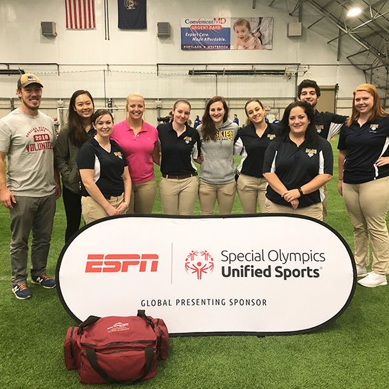 Athletic Training students pose for a photo with a sign for the Special Olympics in front of them.