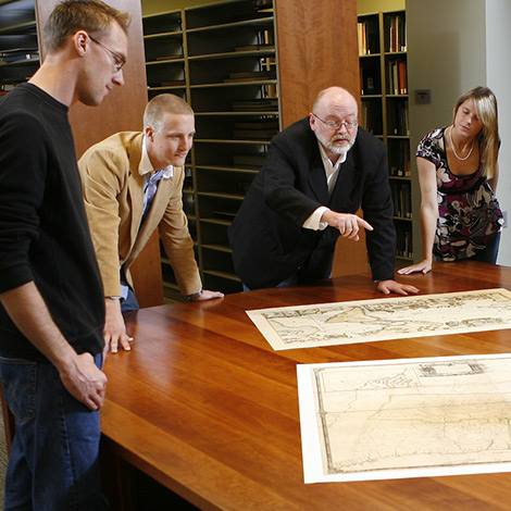 A professor shows students maps in the Osher Map Library.