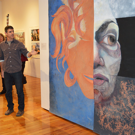 An artist presents details about his large-scale artwork on display at the USM Art Gallery.