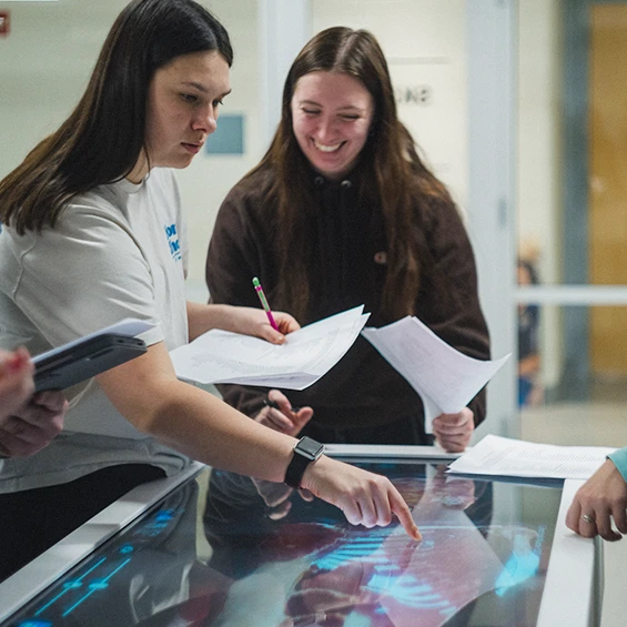 Two students use health science simulation equipment.