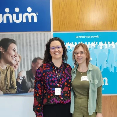 Two interns standing in front of a Unum sign.