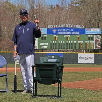 Coach Ed Flaherty accepts retirement gifts including a signed bat and stadium seat.
