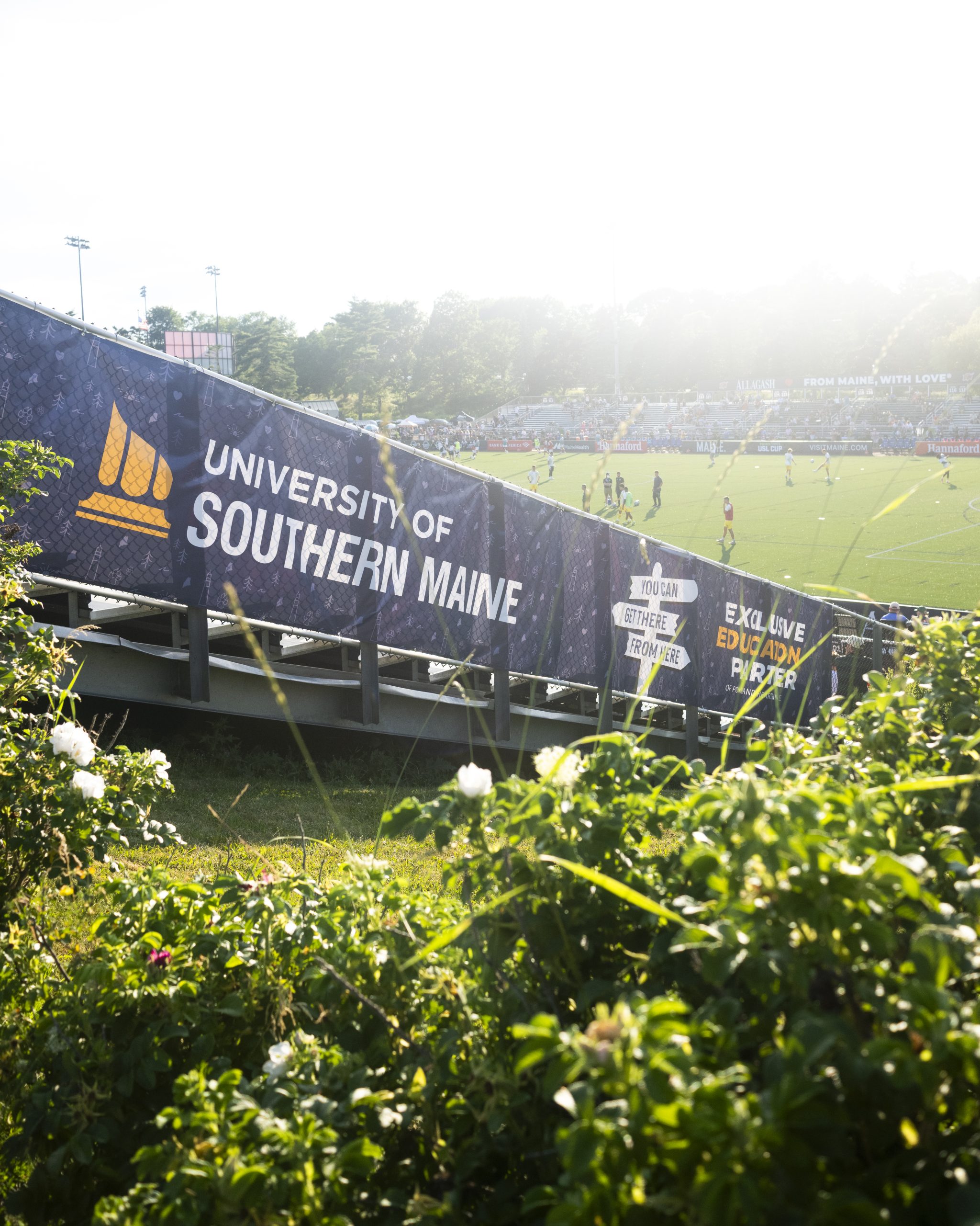 A University of Southern Maine banner marking USM as Exclusive Education Partner lines the stands at Fitzpatrick Stadium during a match.
