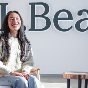 Mandy Ho candidly laughing sitting in the lobby of L.L.Bean headquarters.