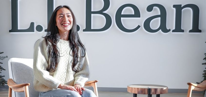 Mandy Ho candidly laughing sitting in the lobby of L.L.Bean headquarters.