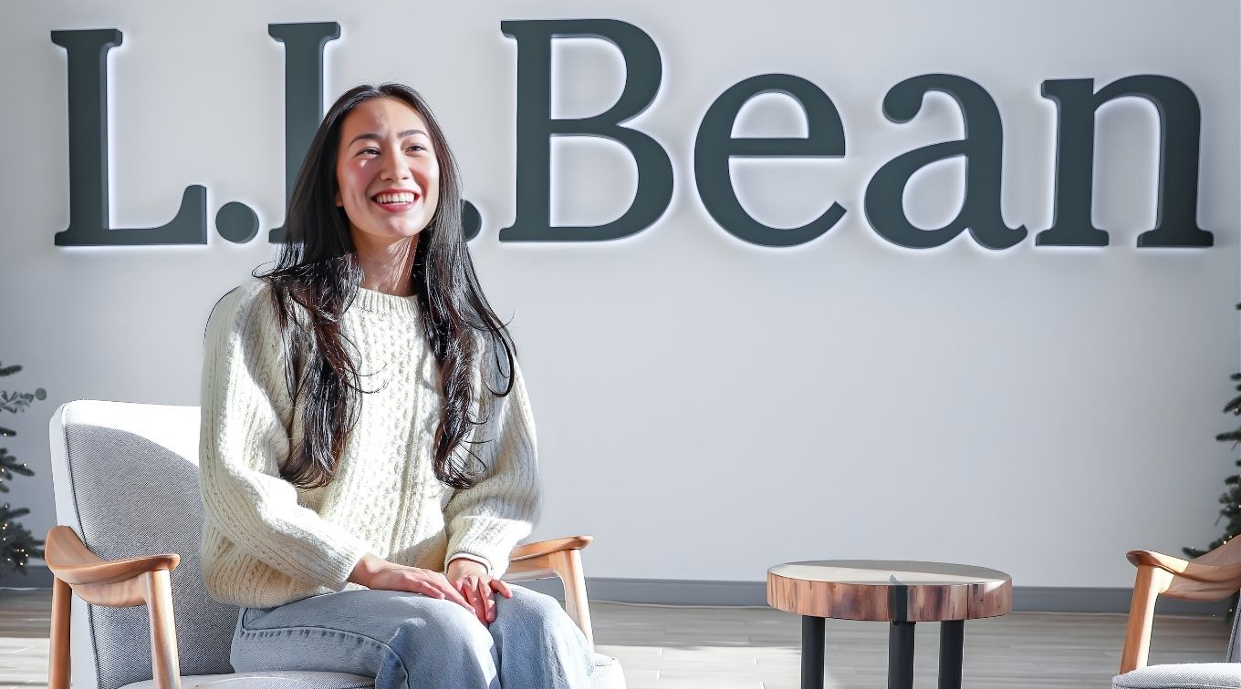 Mandy Ho candidly laughing sitting in the lobby of L.L.Bean headquarters.