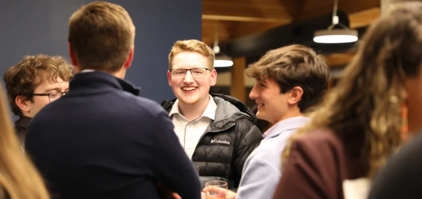 Collin Page and peers laugh, while enjoying mocktails at the Career Hub Networking Dinner this November