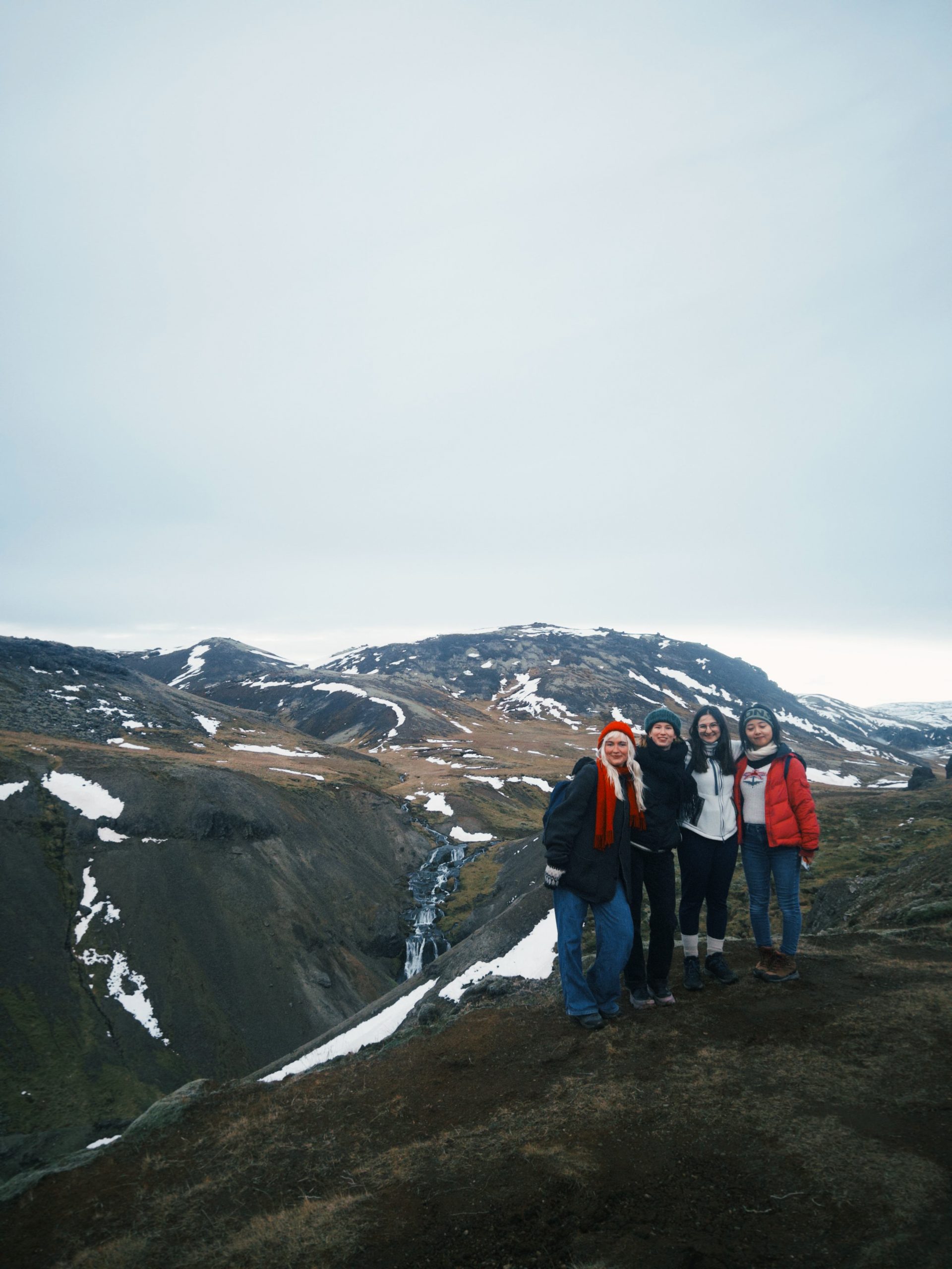 Emma (second from right) smiling with friends while hiking in Iceland's mountains during her Fulbright year