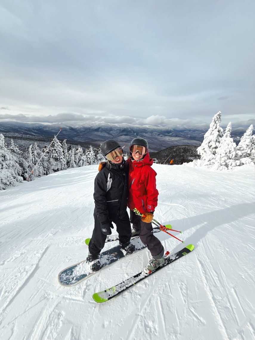 USM Outdoor Adventure Board skier and snowboarder smiling together on the slopes at a Maine ski mountain in winter