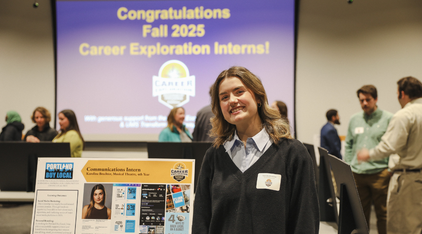 Karoline Brechter stands next to her internship presentation poster at the Career Hub exhibition