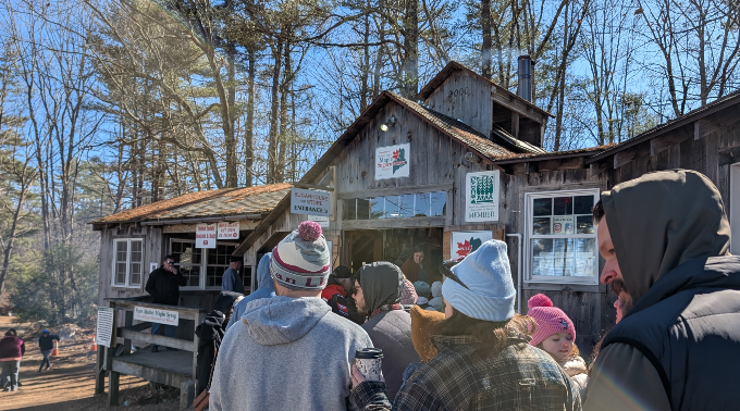 People standing in line at a farm on Maine Maple Sunday waiting to get inside the sugarhouse
