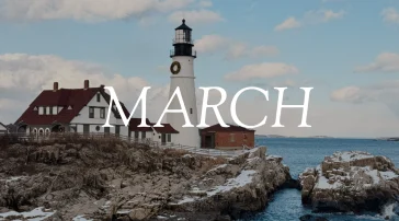 Portland Head Light lighthouse is covered in snow and surrounded by snowy rocks above the ocean. The word "March" overlays the image