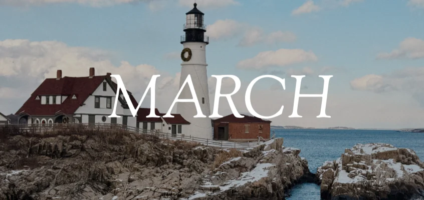 Portland Head Light lighthouse is covered in snow and surrounded by snowy rocks above the ocean. The word "March" overlays the image