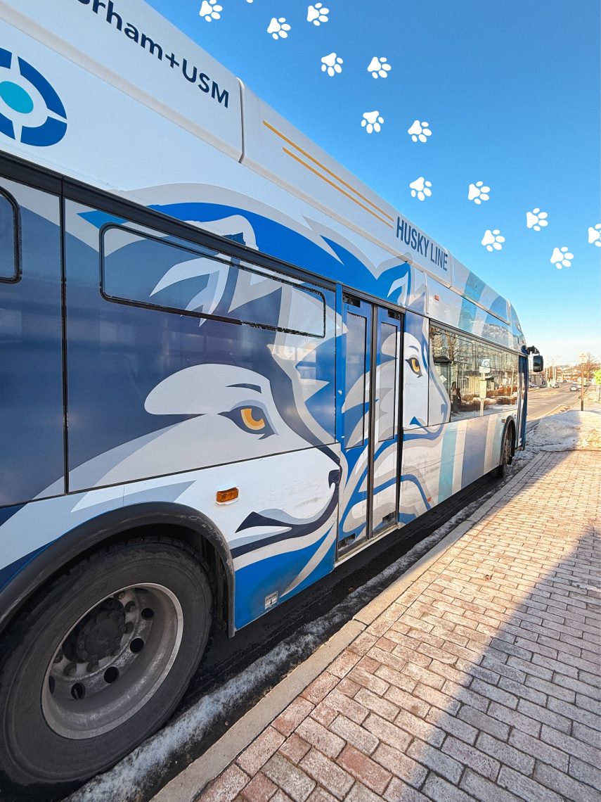 Exterior of USM's Husky Line bus as it stops at a bus stop. Animated paw prints cross the image above the bus.
