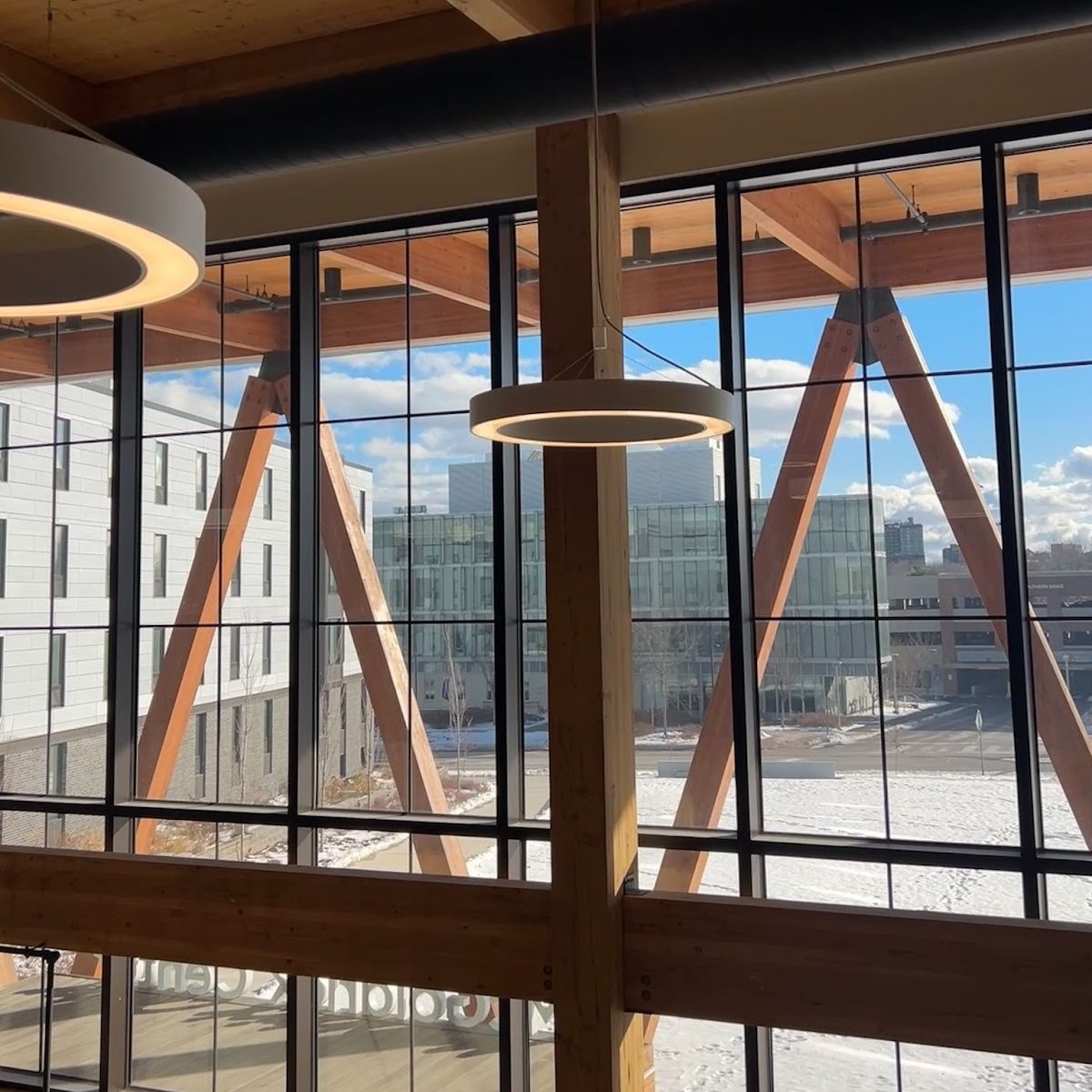 Here are a few options: Simple and clear: "View from a window at USM's McGoldrick Center showing a blue sky and snow-covered ground below.