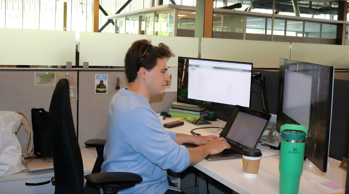 Maxfield Rhine working at his desk as an intern at L.L.Bean