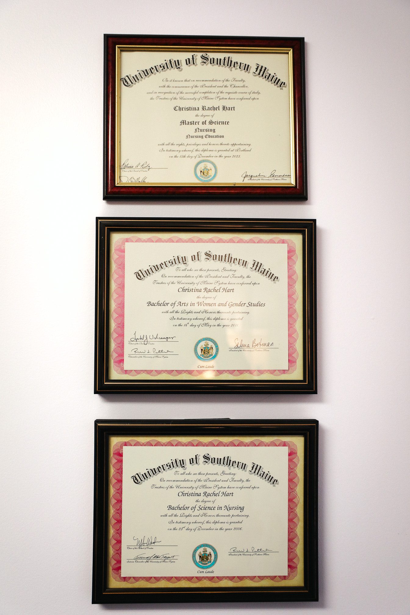 Three University of Southern Maine diplomas belonging to Christina Hart hang vertically in a line on her office wall.
