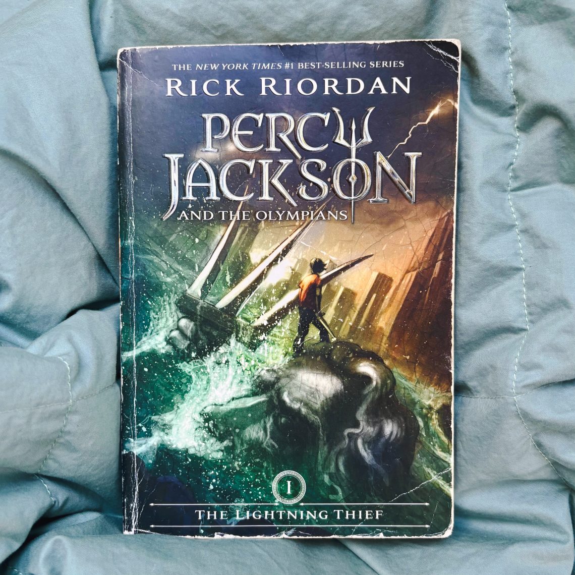 A copy of Percy Jackson & the Olympians: The Lightning Thief on a blanket.