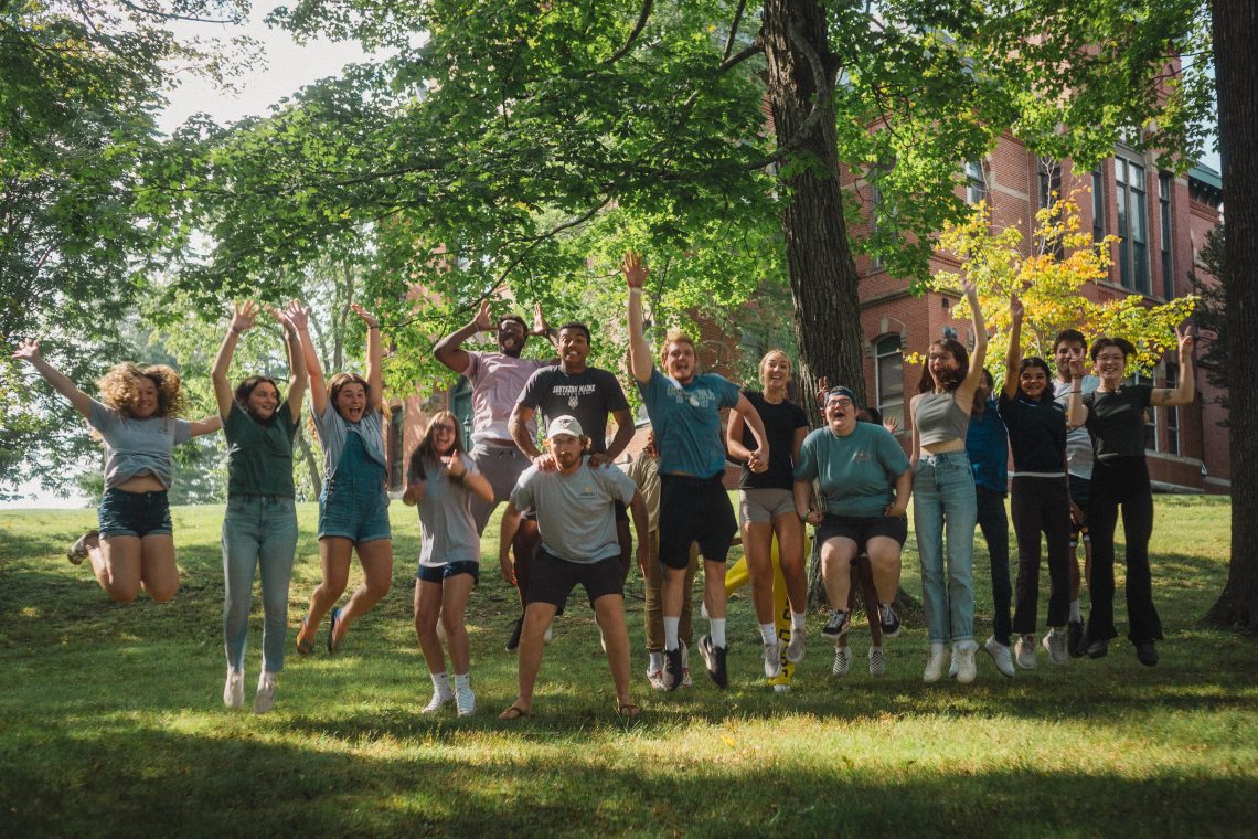 USM student ambassadors jump in the air together outdoors