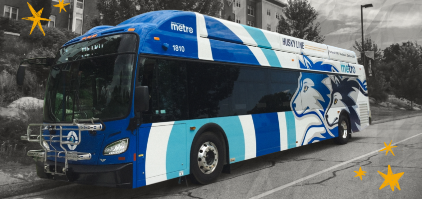 The University of Southern Maine's Husky Line bus stops on the street to pick up students. The background around the bus is black and white, and there are hand drawn yellow stars on either side of the bus.