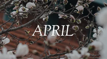 Close-up of delicate pink flower buds emerging on tree branches against a soft spring sky, with bold "April" text overlaid in white.