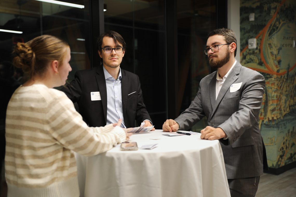 Ted Campbell connects with two other attendees at a table during the Career and Employment Hub's networking dinner.