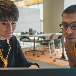 Technology coach helping a student with computer guidance.