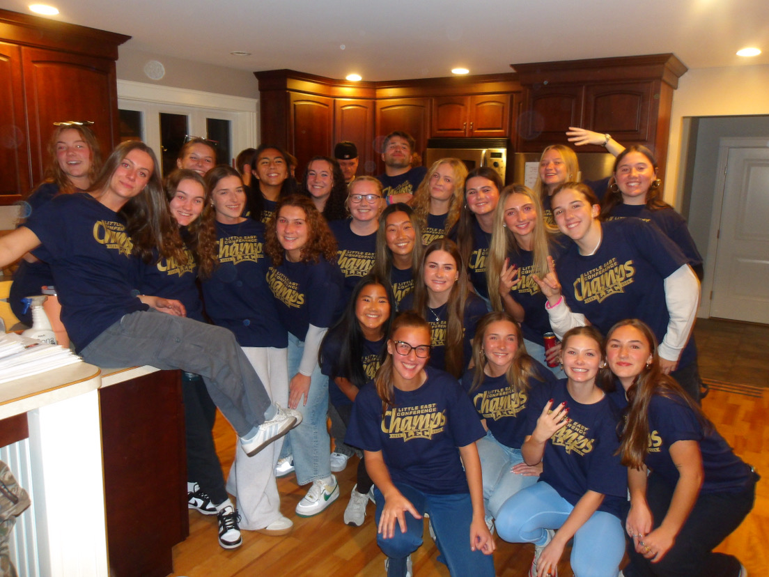 The USM women's soccer team celebrates together in a group photo, wearing Little East Conference champion T-shirts following their fall 2025 championship win.