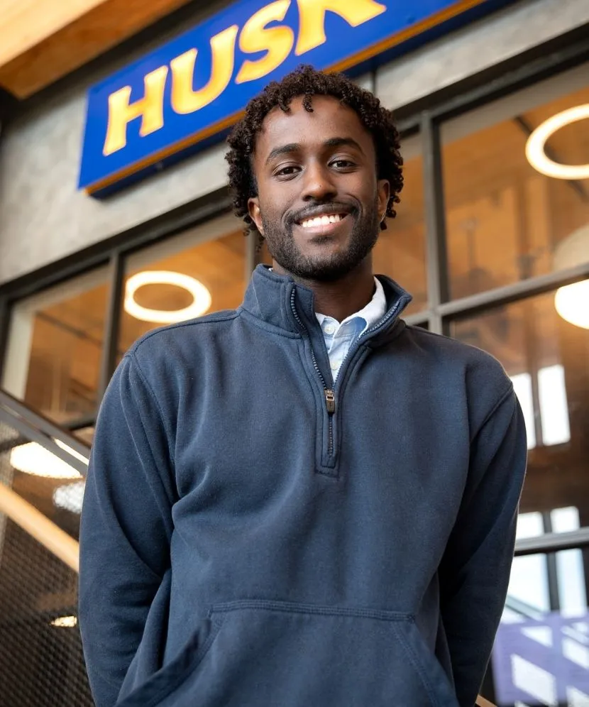 Mohamed Ali standing on the stairs in front of the Husky Brew in the McGoldrick Center.