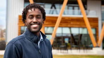 Business analytics student Mohamed Ali on the Bean Green in front of the McGoldrick Center.