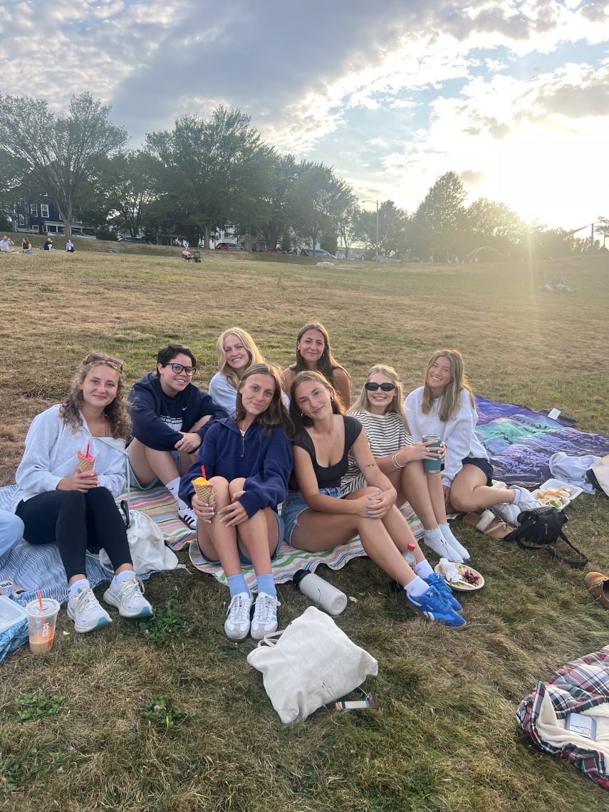 Bridgette and her friends having a picnic on the Eastern Promenade in Portland, Maine, with the harbor and ocean in the background.