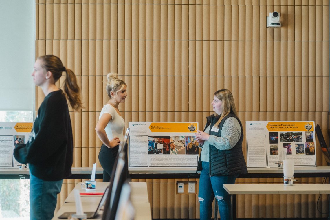 Students conversing at Career Exploration Internship Program poster exhibition