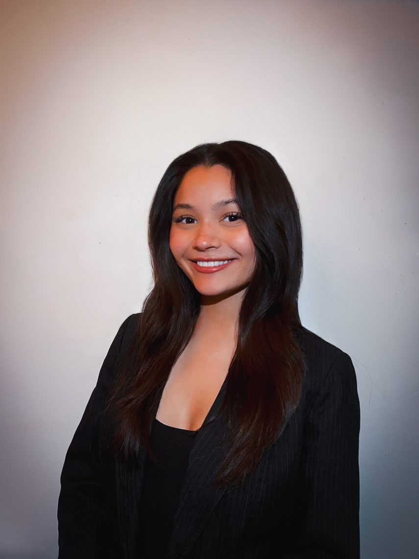 Aja Marzilli poses for a headshot in professional attire against a neutral background.