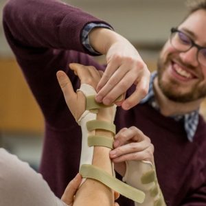Occupational Therapy students practicing proper wrist brace application.