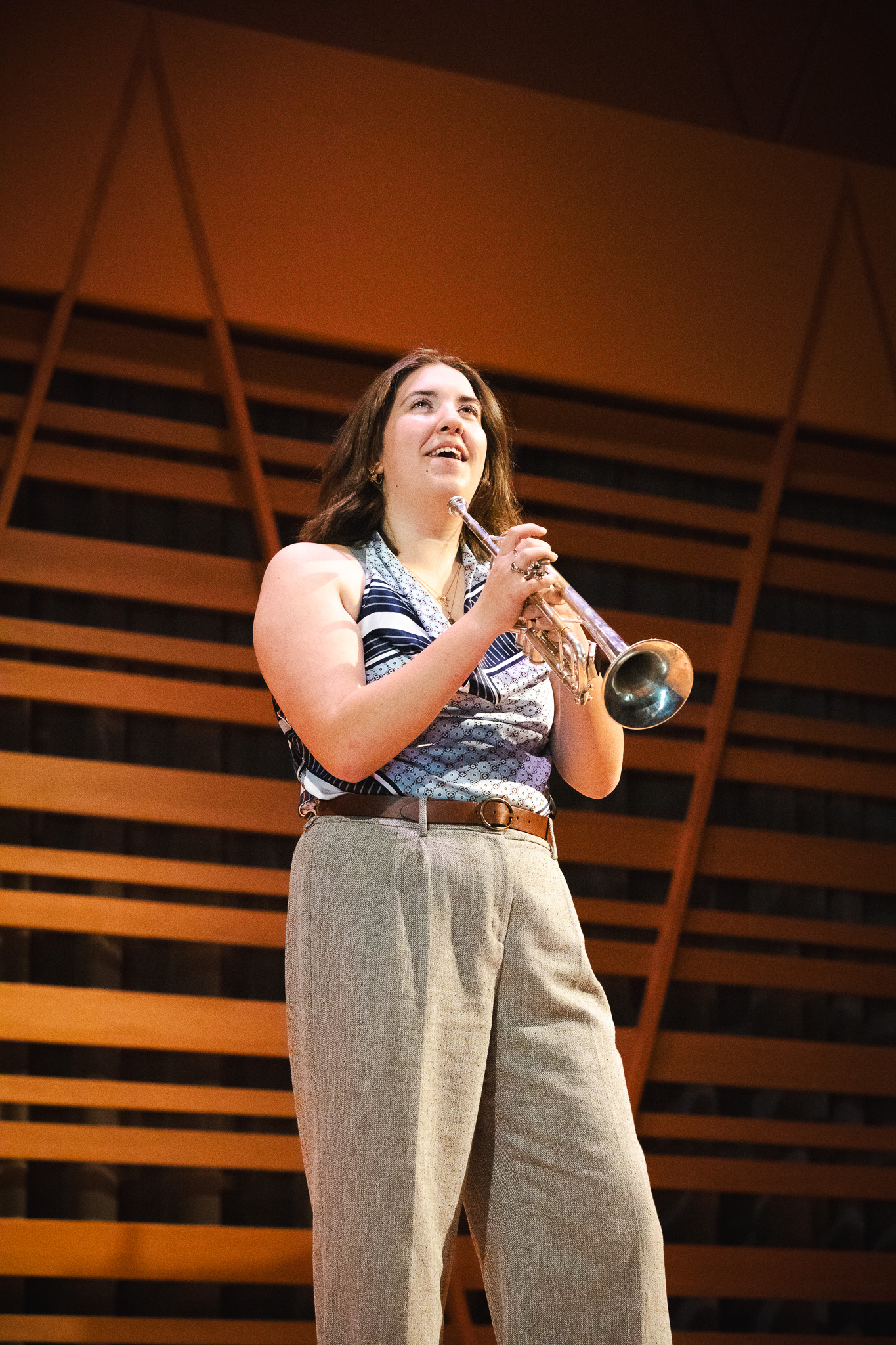Hannah Paterson smiles while holding her trumpet on the Crewe Center's stage.