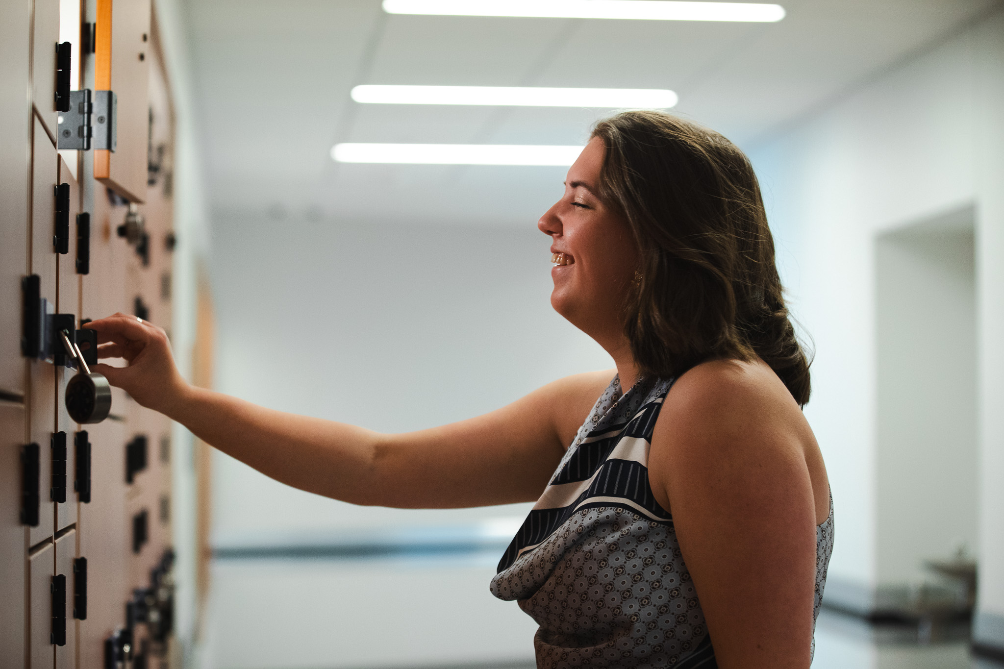 Hannah Paterson laughs while opening her locker in the Crewe Center's storage area.