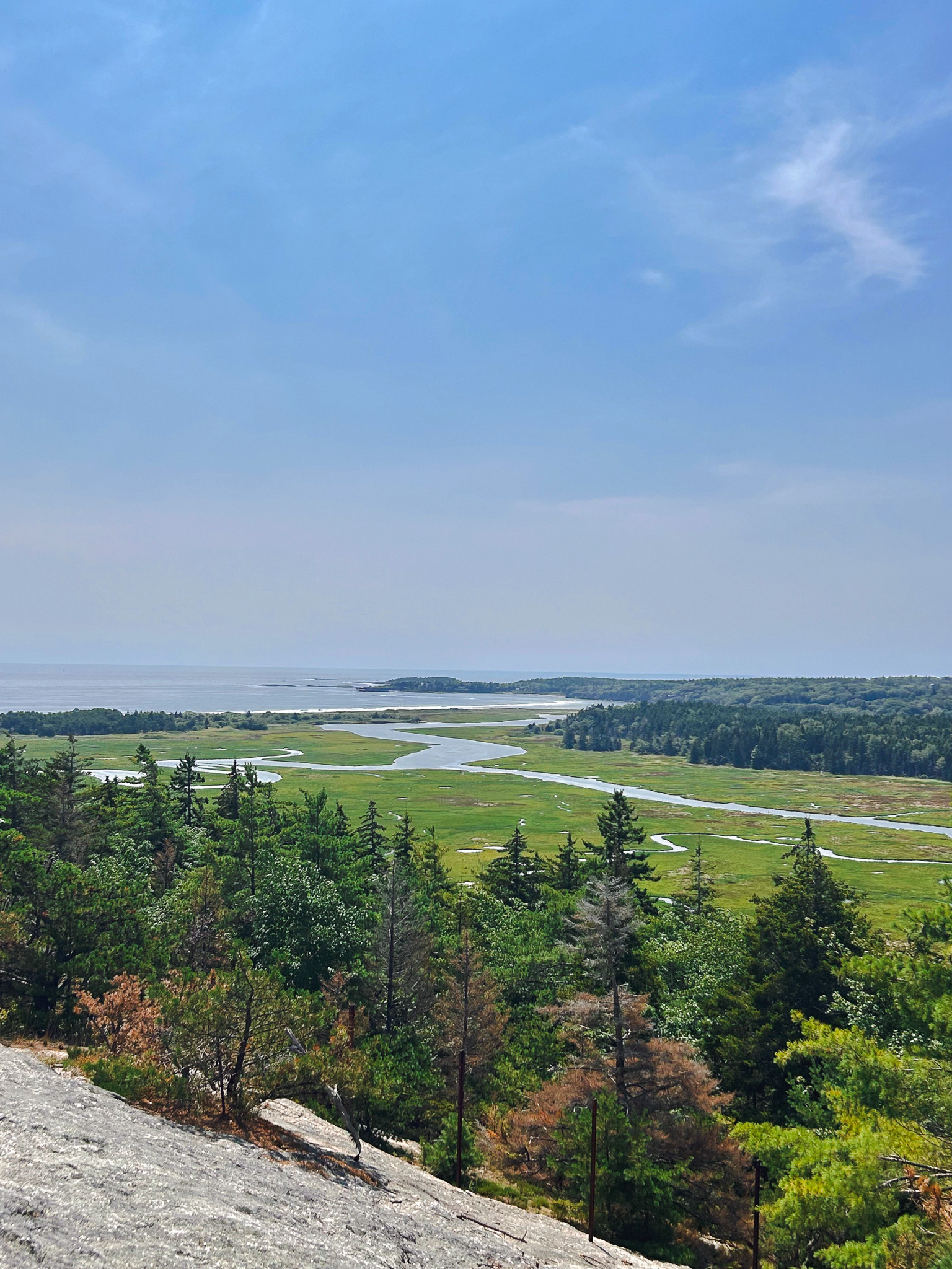 Sweeping summit view from Morse Mountain over winding salt marsh, pine forest, and the Maine coastline toward Seawall Beach