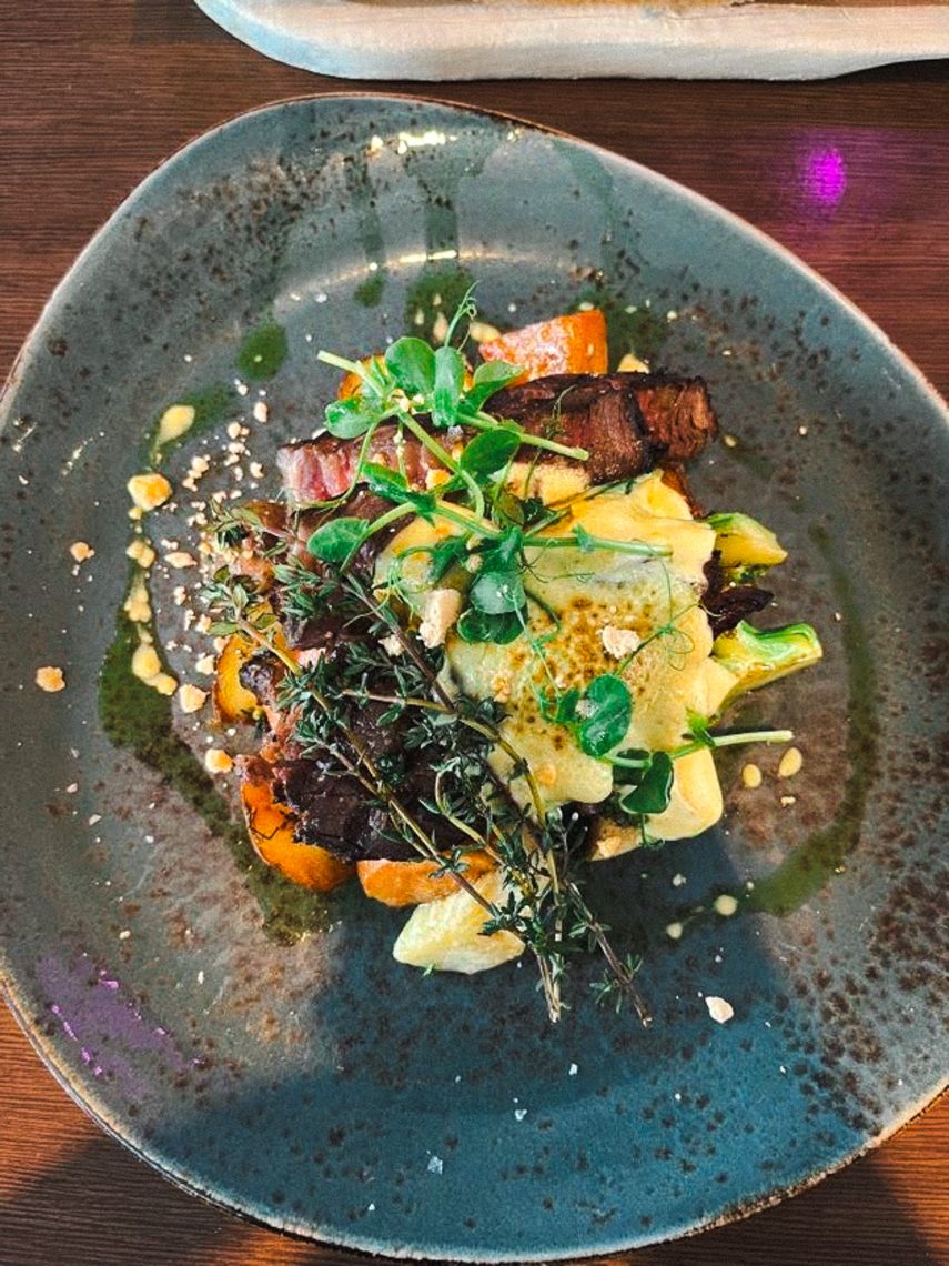 A plated dinner dish garnished with fresh herbs and microgreens served during the Iceland trip